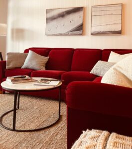 Cozy couch with lots of pillows and reading material.